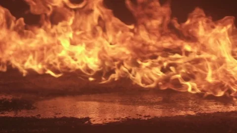 Fire burning next to a reflecting pond in slow motion 動画素材 76800981