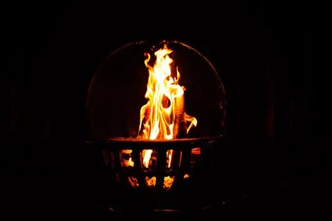 Fire burning in an open fireplace in the dark. low key Stock Photos