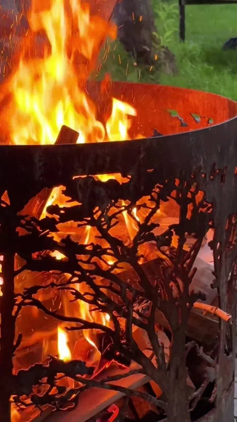Fire burning in an outdoor fire pit at dusk, close up. Vertical 4K footage 動画素材 339867459