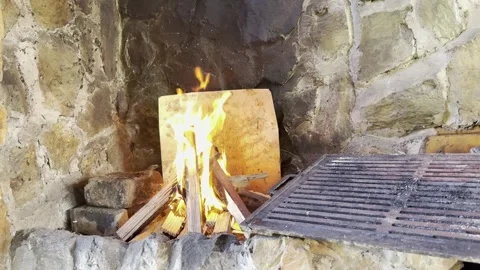 Fire burning in rustic stone fireplace outdoors Stock Footage 333708322