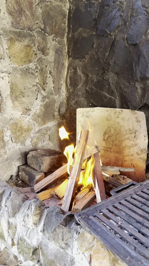 Fire burning in rustic stone fireplace outdoors Stock Footage 333709533