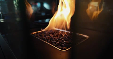 A fire is burning in a small heater container. The fire is orange and yellow. Stock Footage 344915596