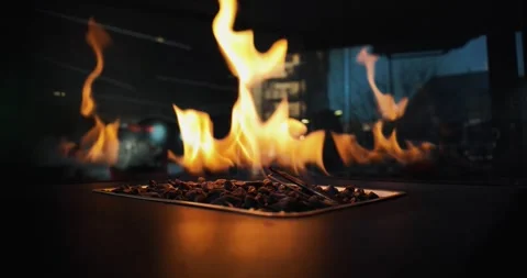 A fire is burning in a small heater container. The fire is orange and yellow. Stock Footage 344915613