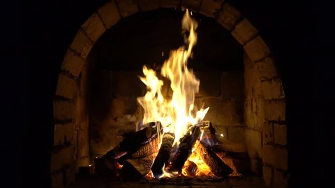 A fire burns in a brick fireplace, keep warm Stock Footage 100430564