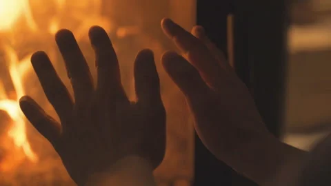 The fire burns in the fireplace. A man warms his hands by the fire. Stock Footage 196275003