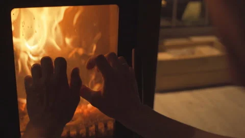 The fire burns in the fireplace. A man warms his hands by the fire. Stock Footage 196275202