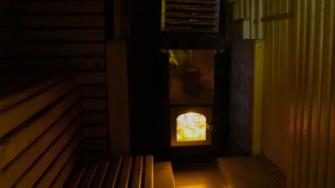 Fire burns in a heater in a sauna Stock Footage 131456019