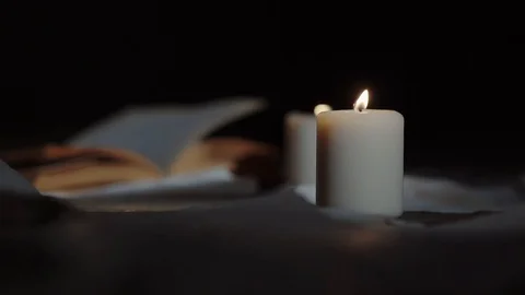 The fire from the candle is flushed, the pages on the book are turned over Video stock 88411246