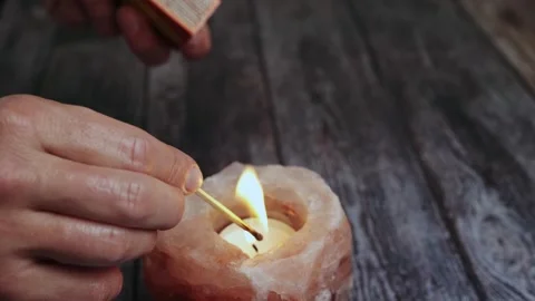 Fire candle scented, close-up of a woman's hand with a burning match lighting a Stock Footage 243284240