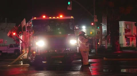 Fire Captain supervising his Fire Fighters Using the Hose Stockbeeldmateriaal 55542450