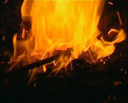 Fire close as a worker pokes the fire Stock Footage 21374484