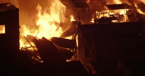 Fire consuming a house in poor settlement Video stock 65797125