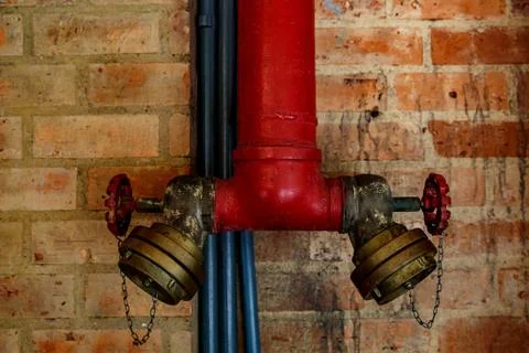 Fire crane on a brick wall background. Stock Photos