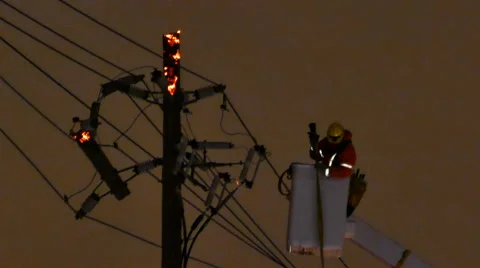 Fire crew attending a power pole fire at night with ambers - Commercial Video stock 49697914