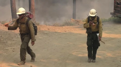 Fire crew walking up road using radio to communicate Stock Footage 40953999