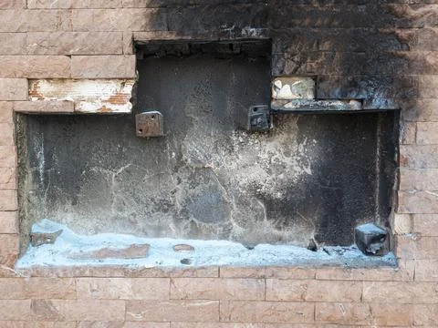 Fire damage shows in brick wall with soot and extinguisher residue Stock Photos