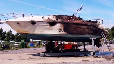 FIRE-DAMAGED speedboat placed on the side. Stock Footage 84931624