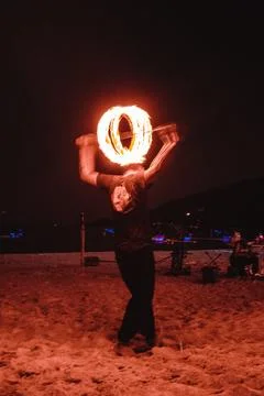 A fire dancer moves balls with ignited fired creating patterns in a long ex.. Stock Photos