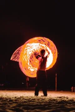 A fire dancer moves balls with ignited fired creating patterns in a long ex.. Stock Photos
