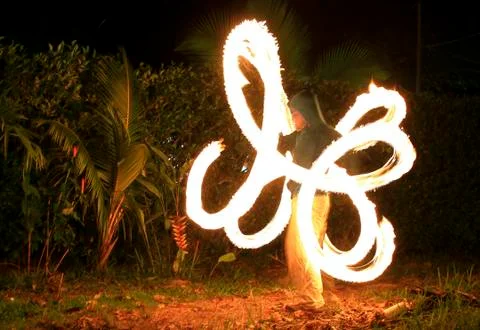 Fire dancer spinning fire on a beach Stock Photos