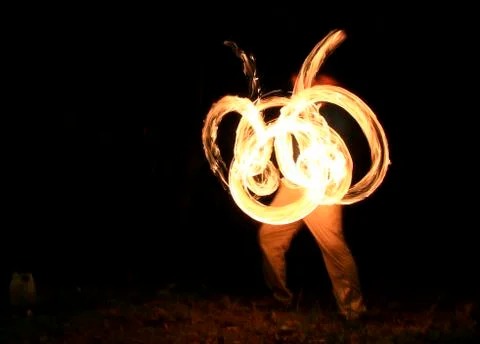 Fire dancer spinning fire on a beach Stock Photos