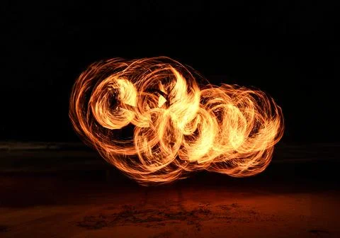Fire dancer swing fire dancing show on the beach at night.  Stock Photos