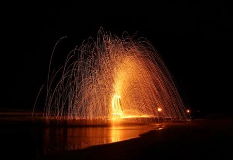 Fire dancer swing fire dancing show on the beach at night.  Stock Photos