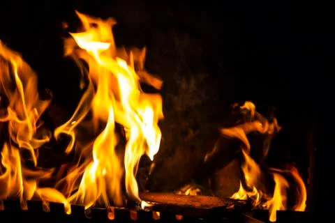 Fire on a dark background. Fire from firewood close up. Flaming burning spark Stock Photos