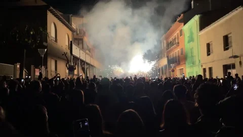 Fire dragon dances in the distance as the crowd admires the pyrotechnic Stock Footage 251680732
