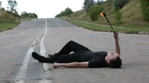 The fire eater, spitting fire, lying on the pavement Stock-Footage 67961447