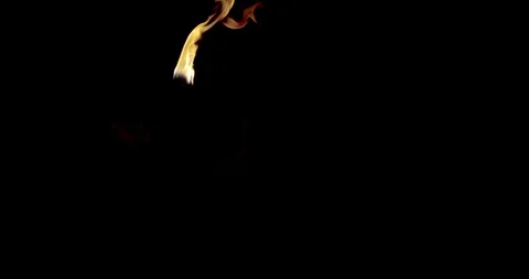 Fire-eating man is breathing flame and putting torch in his mouth in darkness Stock Footage 115413084