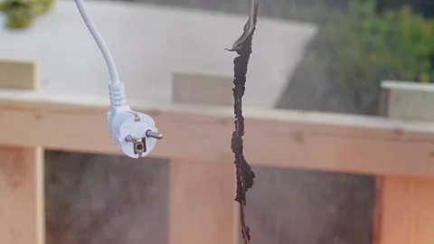 Fire on an electric wire with a plug in the hands of a man.  Vidéo 293803578