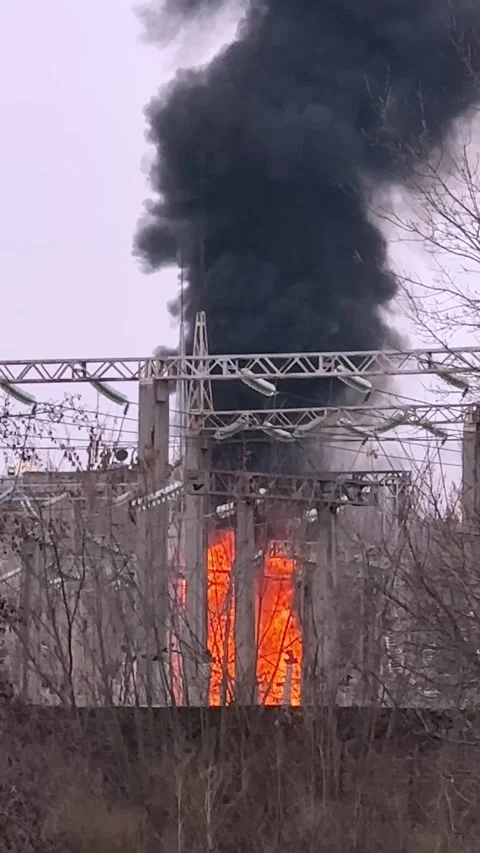 Fire at an energy facility. The transformer is lit. A tall black flame rises up. Stock Footage 307167255