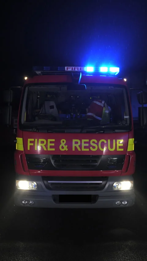 Fire engine and rescue truck flashing blue lights at night. UK. Vertical Stock Footage 330420893