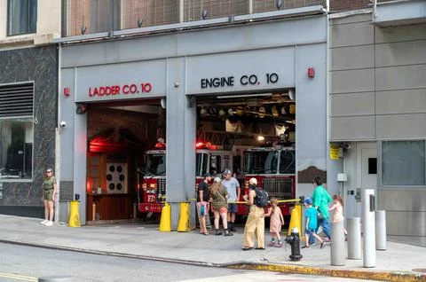 Fire Engine lights flash in FDNY NYC Fire Station doors open onlookers Stock Photos