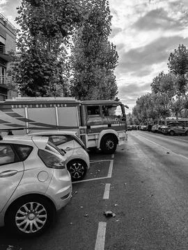 A fire engine parked in a herringbone pattern between cars along the street Stock Photos