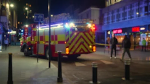 Fire engine standing at emergency scene on night city street with flashing Stock Footage 329066293