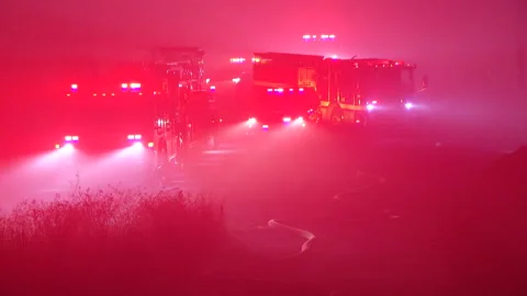 Fire engines surrounded by smoke and fog at night with flashing red lights 스톡 동영상 159695595