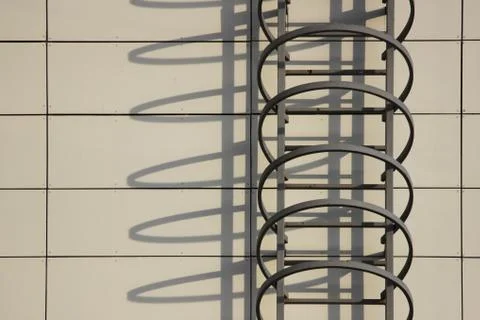 Fire escape and shadow on the wall of an office building. Stock Photos
