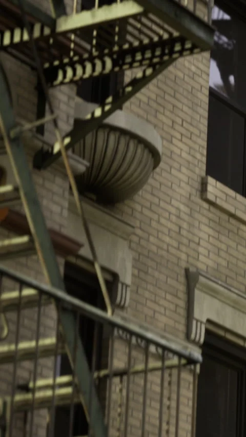 Fire escape on a brick building with a window and dark entrance Stock Footage 336181526