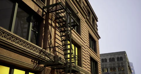 Fire escape on a city building at sunset with contrasting warm hues Stock Footage 311801295
