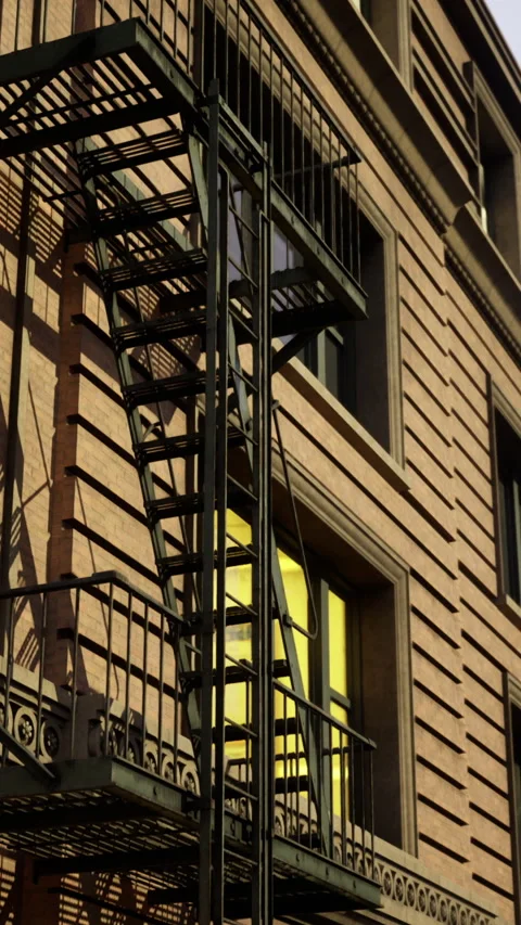 Fire escape on a city building at sunset with contrasting warm hues Stock Footage 317960245