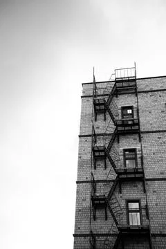 Fire escape framework on a brick building in black and white with clear sky back Stock Photos