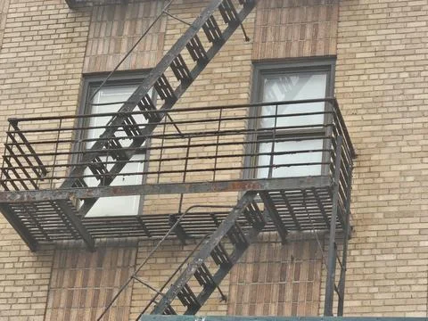 Fire escape ironwork against brick wall Stock Photos