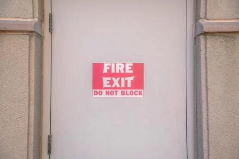 Fire Exit Do Not Block on a beige door at downtown Tucson, Arizona Stock Photos
