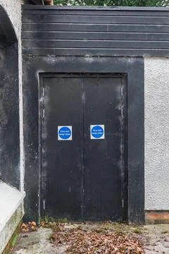Fire exit doors with keep clear safety signs on building exterior Stock Photos