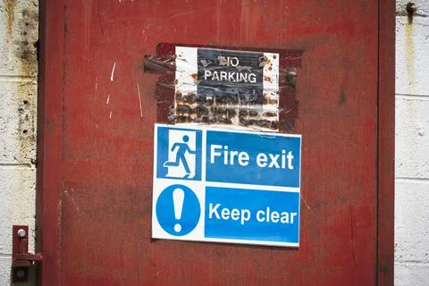 Fire exit keep clear sign on construction building site door Stock Photos