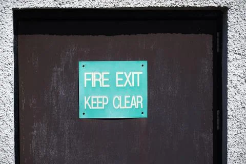 Fire exit keep clear sign on construction building site door Stock Photos