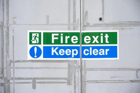 Fire exit keep clear sign on construction building site door Stock Photos