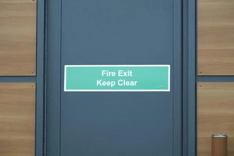 Fire exit keep clear sign on construction building site door Stock Photos